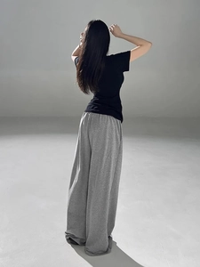 Rear view of black short sleeve slim t-shirt and grey wide leg lounge pants on model