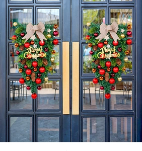 Christmas door teardrop wreath with pine cones and red baubles on a glass door