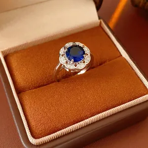 Hollow rhombus flower open ring with blue zircon in a luxury velvet jewelry box