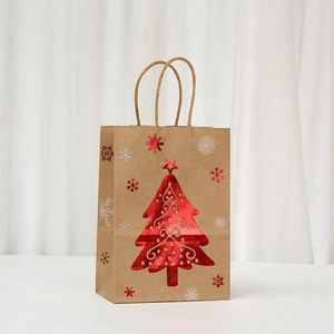 Close-up of brown kraft Christmas gift bag with a metallic red tree and snowflake pattern