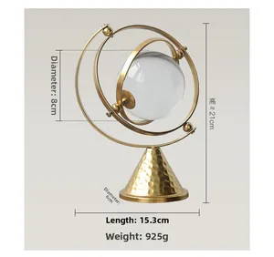 Detailed view of luxury crystal ball ornament with gold metal orbit and hammered base
