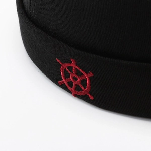 Minimalist black docker hat with red ship wheel embroidery in high-density stitching