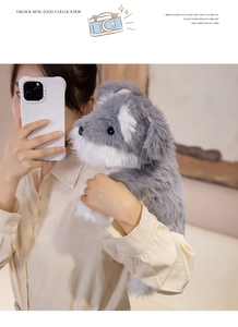 Close-up of a soft grey and white schnauzer plush toy in a cozy lifestyle setting