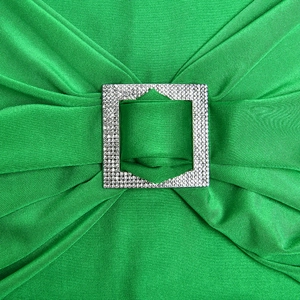 Detail of green ruched fabric with sparkling rhinestone square buckle on sexy summer dress
