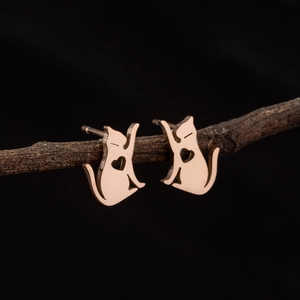Minimalist rose gold cat stud earrings with heart cut-out design on a wooden branch