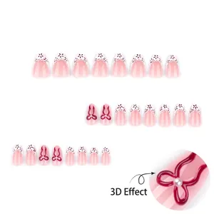 Short almond press-on nails with pink gradient, white lace, and 3D red ribbon bows