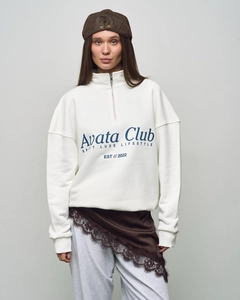 Close-up of oversize white sweatshirt featuring half-zip collar and blue letter printing