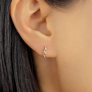 Sparkling gold geometric hoop earrings with zircon stones on female model ear