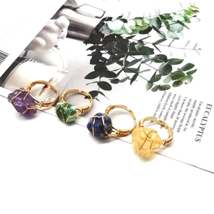 Detailed view of four handmade wire-wrapped natural raw stone rings in assorted colors