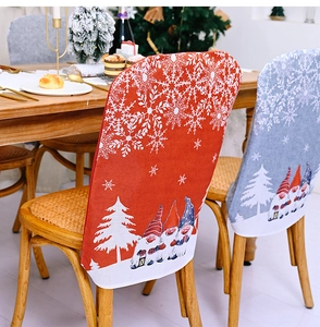 Detail of Christmas chair covers featuring gnomes and snowflakes on wooden dining chairs