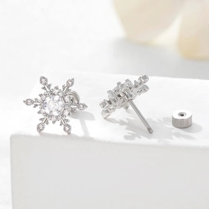 Sparkling silver snowflake earrings with cubic zirconia stones on white display