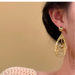 Close-up of model wearing 18k gold plated multi-layer hollow teardrop earrings