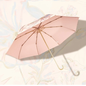 Detailed view of an open pink floral sun umbrella with reinforced gold metal ribs