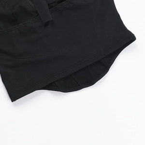 Detailed macro view of the curved hem and double stitching on the black halter neck top
