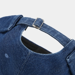 Close-up of adjustable metal buckle and stitching on dark blue denim docker cap