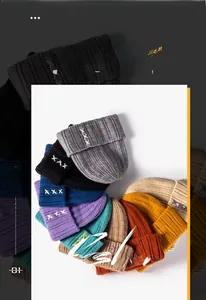Detail showing colorful knitted winter beanies with unique cross-stitch embroidery accents