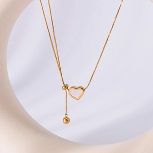 Minimalist 18k gold plated necklace with shell heart and round bead charms on a white prop