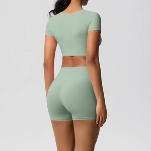 Rückansicht eines Modells in salbeigrünem, nahtlosem Crop-Top und High-Waist-Yoga-Shorts