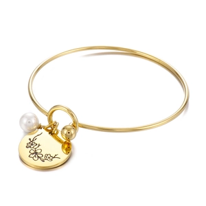 Golden stainless steel birth flower bangle featuring a floral charm and a white pearl accent