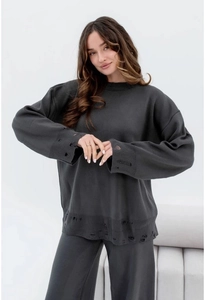 Detail of distressed knit sweater with ripped cuffs and hem in dark gray solid color