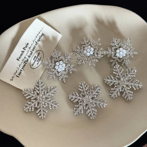 Close-up of snowflake hair clips with sparkling rhinestones and white pearls set of six