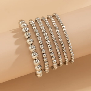 Detail shot of a 6-piece silver beaded bracelet set with heart charms on display