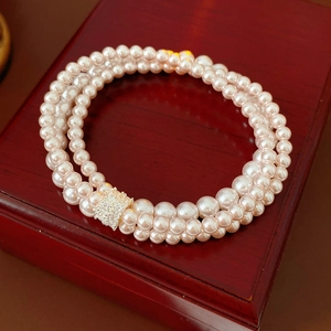Close-up of triple-strand pink pearl bracelet with a sparkling crystal-encrusted clasp
