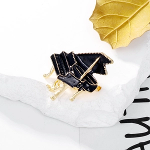 Broche de piano à queue artistique en émail noir et finition dorée sur pierre texturée