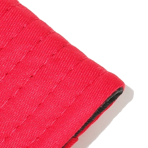 Detailopname van rode getextureerde stof met horizontale stiksels op de hoed