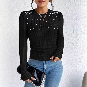 Detail of elegant black ribbed knit top with pearl embellishments on the shoulders