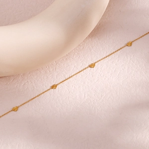 Minimalist gold plated stainless steel necklace featuring multiple engraved heart pendants