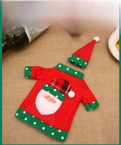 Detailed view of Santa knit wine bottle cover with hat on a burlap holiday table setting