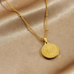 Vintage gold plated 1945 Dos Pesos coin pendant necklace on champagne silk background