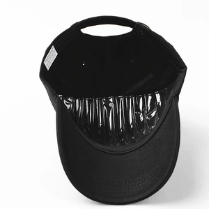 Detail view of the black cotton baseball cap interior with wash label and reinforced seams