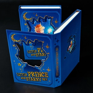 Detail of blue hardcover book Little Prince and Starry Sky with gold glitter hollow design