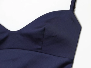 Detail of dark blue satin slip dress neckline with smooth woven texture and stitching
