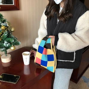 Checkerboard knit tote bag in vibrant colors shown in a cozy indoor lifestyle setting