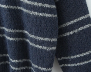 Detail shot of striped knit sweater showing blue and grey mohair texture and soft fibers