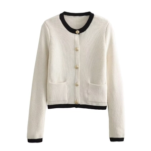 Detailed view of cream knit cardigan with black contrast trim and golden buttons