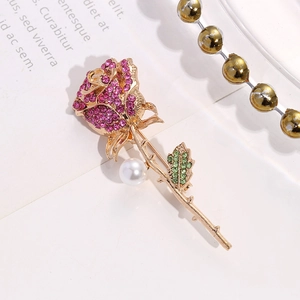 Elegant rose brooch in gold finish with pink rhinestones, green leaves and white pearl