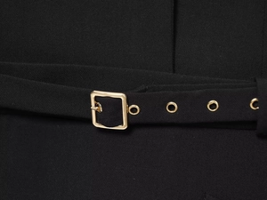 Detail of black mini blazer dress showing gold square belt buckle and metallic eyelets