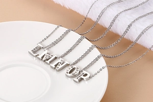 Close-up of crystal paved uppercase letter pendants L to P on stainless steel chains
