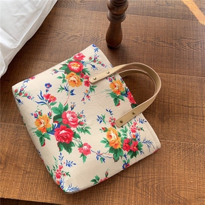 Detail of vintage floral tote bag with sturdy PU leather handles and metal rivets