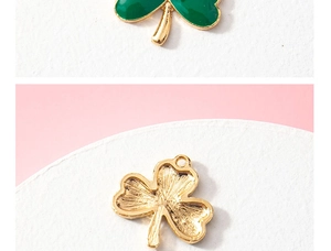 Detail view of green clover charm pendant with gold metal edges showing both sides