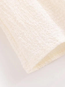 Close-up detail of white textured waffle fabric showing high-quality cotton blend material