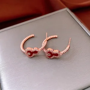 Rose gold Mickey earrings with red enamel and white zircon crystals on a velvet base
