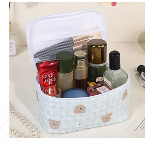 Detail of blue plaid makeup bag showing internal mesh slots and large storage space