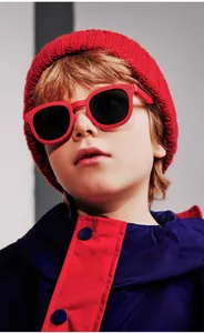 Detailed view of child wearing red wide-frame sunglasses with dark polarized lenses