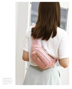 Detailed back view of pink quilted fanny pack with multi-zipper compartments on model