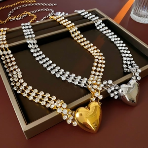 Makroaufnahme von Strass-Halsketten mit polierten Herzanhängern in Gold und Silber